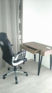 un escritorio y una silla junto a una mesa en Location chambre dans une charmante et grande maison duplex neuve et bien aérée, en La Verrière