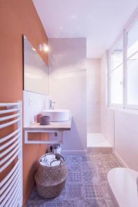 uma casa de banho com um lavatório e uma cesta de toalhas em Charmant appartement - Chambre séparée - 300m de la gare et accès direct au cœur historique em Poitiers