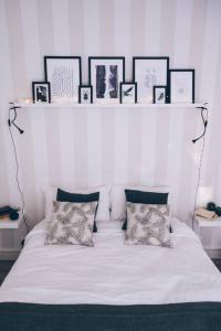 - un lit blanc avec des oreillers et des photos sur une étagère dans l'établissement Charmant appartement - Chambre séparée - 300m de la gare et accès direct au cœur historique, à Poitiers