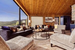 a living room with a couch and a table and chairs at The View - Hodlekve in Sogndal