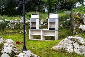 uma estante de livros branca sentada em cima de uma pilha de pedras em Apartamentos Baldenora em Llanes