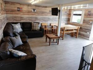 ein Wohnzimmer mit einem Sofa und einem Tisch in der Unterkunft Log cabin with secure garden in Haxey