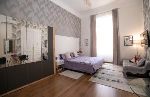 a bedroom with a bed and a chair and a window at Casa Larisa in Arad