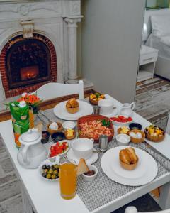 a table with plates of food and a fireplace at Best Center Boutique Hotel in Baku
