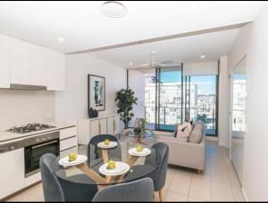 una cucina e un soggiorno con tavolo e sedie di Axle x Apartment a Brisbane