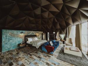 a bedroom with a geometric wall with a bed and a couch at Alaçatı Route 35 Glamping Konaklama&Restaurant in Germiyan