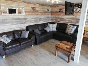 ein Wohnzimmer mit einem Sofa und einem Tisch in der Unterkunft Log cabin with secure garden in Haxey