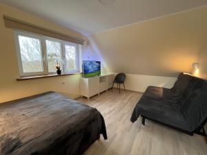 1 dormitorio con 1 cama y escritorio con TV en Jõesuu saunamaja, en Valga