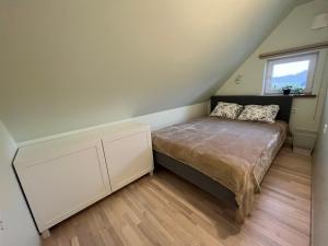 een kleine slaapkamer met een bed en een raam bij Jõesuu saunamaja in Valga