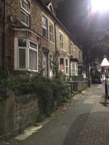 una calle vacía al lado de un edificio de ladrillo por la noche en Raja's House, en Nether Edge