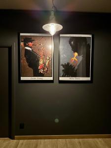 three framed pictures on a wall with a light at Jazz Apartament Częstochowa Centrum 2-bedroom in Częstochowa