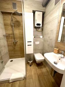 a bathroom with a shower and a toilet and a sink at Jazz Apartament Częstochowa Centrum 2-bedroom in Częstochowa
