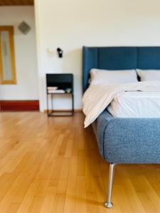 a bedroom with a blue bed and a wooden floor at B17 Two Bed Apartment West Town in Heidenheim an der Brenz
