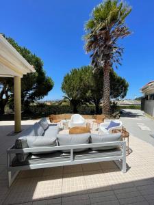 eine Terrasse mit weißen Möbeln und einer Palme in der Unterkunft Preciosa casa entre Lisboa, Cascais y Sintra in Fuente el Saz