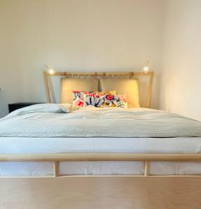 a bed with a wooden frame with pillows on it at B17 Two Bed Apartment West Town in Heidenheim an der Brenz
