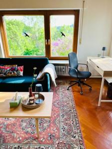 ein Wohnzimmer mit einem Sofa, 2 Stühlen und einem Tisch in der Unterkunft B17 Two Bed Apartment West Town in Heidenheim
