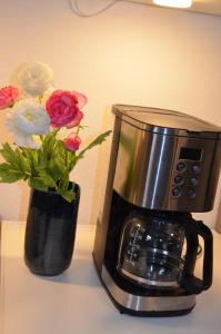 a coffee pot and a vase of flowers on a counter at Vier-Zimmer-Wohnung mit Garten zwischen Salzburg und Königssee in Ainring