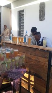 a group of people sitting at a bar with drinks at PREM VILLA in Petit Raffray