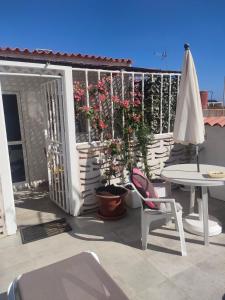 eine Terrasse mit einem Tisch, einem Stuhl und einem Sonnenschirm in der Unterkunft Casa Alba 2 in Puerto del Rosario