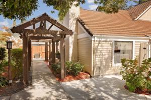 a house with a wooden archway in front of a driveway at Residence Inn San Jose Campbell in Campbell