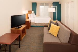 a living room with a couch and a tv and a bed at Residence Inn San Jose Campbell in Campbell