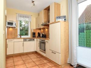 a kitchen with white appliances and a window at Haus Maja in Kaltenhof +12 photos