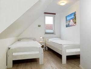 two beds in a room with a staircase at Haus Maja in Kaltenhof