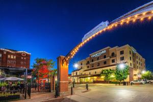 un arco iluminado en una ciudad por la noche en Courtyard by Marriott Wichita at Old Town en Wichita