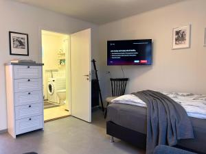 sypialnia z łóżkiem i telewizorem na ścianie w obiekcie Cozy Bungalow w Reykjavík