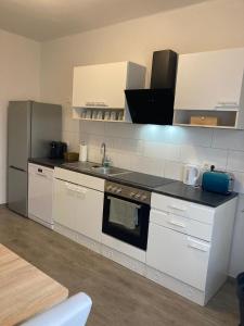 a kitchen with white cabinets and a sink at Wohnung in Haus in Neunkirchen