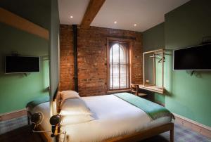 1 dormitorio con cama, ventana y TV en O'Regans en Dublín