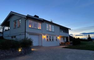 a large house with a garage at dusk at Koselig rom i rolige omgivelser in Åmot