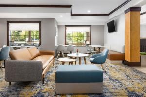 uma sala de estar com um sofá, cadeiras e mesas em TownePlace Suites by Marriott Roswell em Roswell