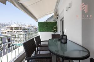 einen Balkon mit einem Glastisch und Stühlen in der Unterkunft Lusso Bianco, Nilie Hospitality MGMT in Thessaloniki