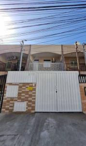 ein Haus mit einem weißen Tor davor in der Unterkunft Casa 2/4 para temporada in Aracaju