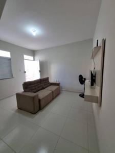 a living room with a couch in a white room at Casa 2/4 para temporada in Aracaju