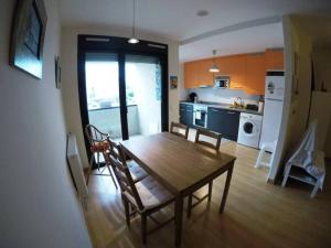 cocina y comedor con mesa de madera y sillas en apartamento en Colunga, en plena naturaleza, en Colunga