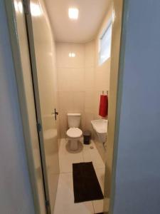 a small bathroom with a toilet and a sink at Casa 2/4 para temporada in Aracaju