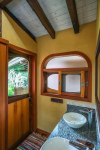 a bathroom with a sink and a mirror at Chalés na Fazenda Ritmos da Terra in Angelina