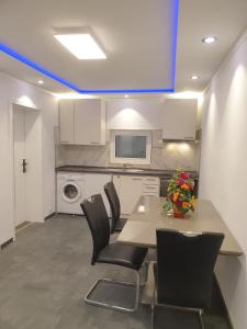 eine Küche mit einem Tisch, Stühlen und einer Mikrowelle in der Unterkunft Schlafzimmer Nr1 Heidingsfeld Würzburg in Würzburg