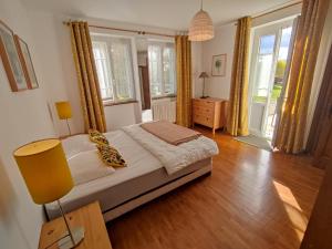 um quarto com uma cama num quarto com janelas em Villas du Lac em Clairvaux-les-Lacs