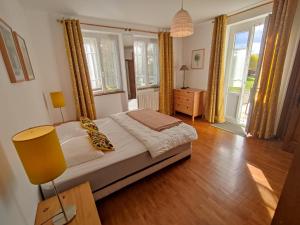 a bedroom with a bed in a room with windows at VILLAS-DU-LAC Appartements de vacances et Espace Spa privé in Clairvaux-les-Lacs