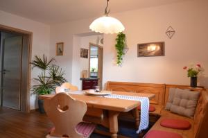 comedor con mesa de madera y silla en Vier-Zimmer-Wohnung mit Garten zwischen Salzburg und Königssee, en Ainring