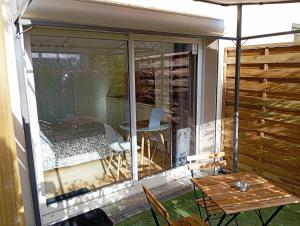 a screened in porch with a table and a table at Le Clos Lassagne -Terrasse privative - Climatisation - Lyon Sud - Brignais in Brignais +38 photos