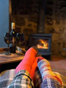 a person in colorful socks sitting in front of a fireplace at The Cranny 2 Bed House in Central Morpeth in Morpeth