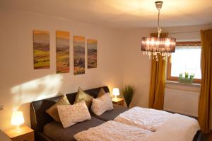 a bedroom with a bed and paintings on the wall at Vier-Zimmer-Wohnung mit Garten zwischen Salzburg und Königssee in Ainring