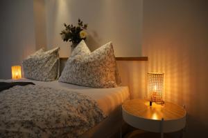 a bedroom with a bed with pillows and a table with a lamp at Ferienwohnung Waldfrieden in Absam