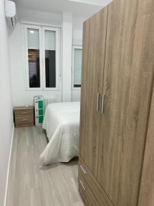a bedroom with a large wooden cabinet next to a bed at Moncloa apartment, con parking in Madrid