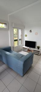 1 dormitorio con 1 cama azul grande y TV en Balzac en Montfort-sur-Meu