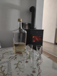 a bottle of whiskey sitting on a table with two glasses at Vikendica Ninic in Laktaši